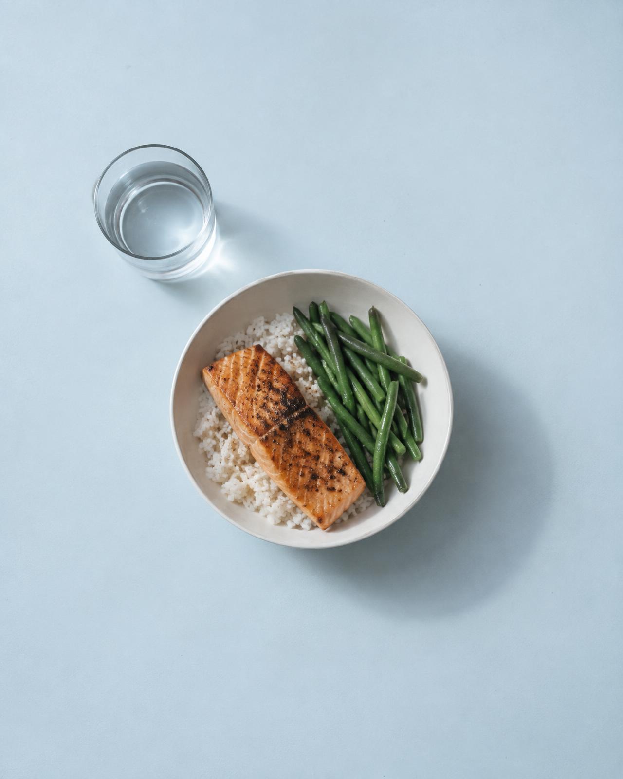 Plato de arroz con salmón y judías verdes visto desde arriba